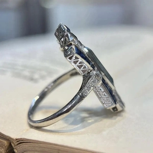 Macro detail of silver ring with blue gemstone and hollow carved vintage patterns