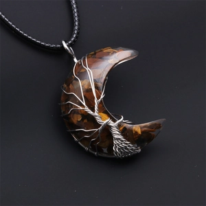 Macro view of tiger eye crescent moon pendant with silver wire-wrapped tree of life