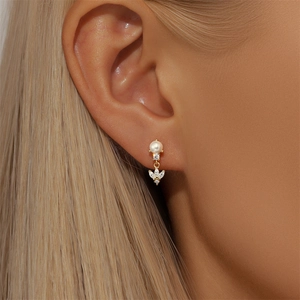 Close-up of S925 silver petal stud earring with white pearl and marquise zircon on ear
