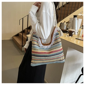 Close-up of colorful woven straw tote bag featuring white lace trim and thick hemp rope straps