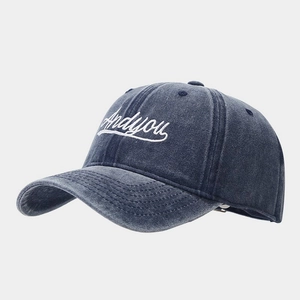 Detail of vintage washed blue baseball cap featuring white Andyou embroidery texture