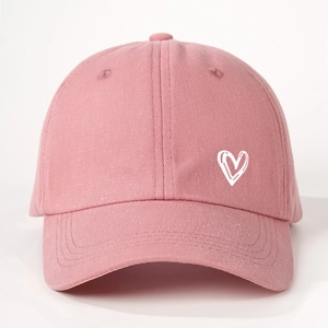 Close-up of pink cotton baseball cap with white heart embroidery and twill texture