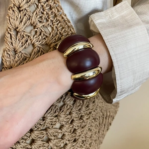 Close-up of vintage acrylic patchwork bracelet in burgundy and gold on a female wrist
