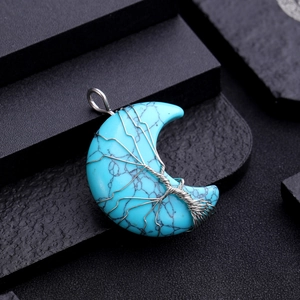 Macro shot of turquoise moon pendant with silver wire-wrapped tree of life design