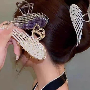 Detailed view of angel wing hair claw with cat eye stones and rhinestones for women