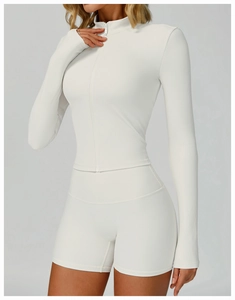 Macro detail of ribbed texture on white stand-collar yoga jacket and matching shorts