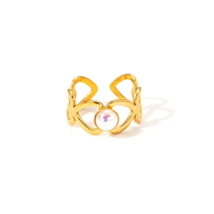 Détail d'une bague coeur ajourée dorée 18k avec une perle d'opale aux reflets arc-en-ciel