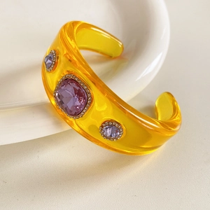 Macro shot of vintage resin bangle with embedded purple crystals and sparkling rhinestones
