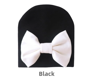 Detail of baby beanie featuring high-elastic cotton fabric and large white bow