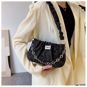 Detail of black pleated shoulder bag featuring a silver flower chain and JING PIN label