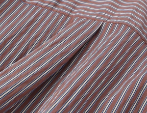 Detailed macro view of high-quality striped poplin fabric with fine stitching and pleats