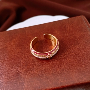 Macro shot of 18k gold plated clover ring with red enamel and sparkling cubic zirconia