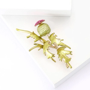 Elegant gold-tone enamel primrose brooch with green fruit and pink bead accents on white base