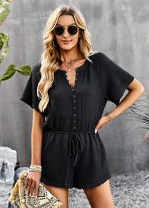 Detail of black short sleeve romper with V-neck button placket and drawstring waist