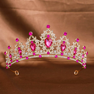 Detailed shot of golden bridal tiara with sparkling magenta gemstones and crystals