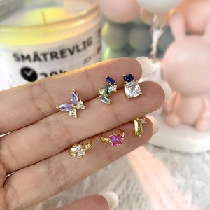 Detailed view of 18k gold stud earrings with colorful zircon and butterfly shapes
