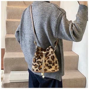 Detailed view of plush leopard print bucket bag with gold chain and pearl drawstring charms