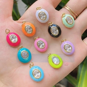 Detail of colorful oval enamel pendants with cubic zirconia inlay in ten vibrant colors