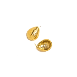 Detailed view of gold teardrop earrings with horizontal textured lines on white background