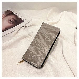 Detailed close-up of grey long wallet with unique paper-like texture and gold zipper