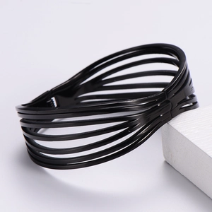 Vue détaillée d'un bracelet large noir multicouche sur un fond blanc minimaliste