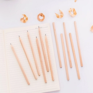 Natural hexagonal wooden HB pencils scattered on a notebook for drawing and sketching