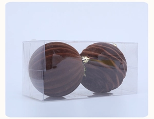 Detail view of two brown flocked Christmas balls with wavy texture in a clear box