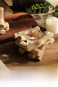 Detalle de un portavelas de madera rústica con vaso de cristal y vela blanca encendida