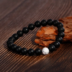 DIY black matte agate and white marble stone beaded bracelet set on a natural wood base