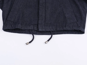 Nahaufnahme des dunkelblauen Jeansjacken-Saums mit elastischem Bund und Metall-Kordelzug