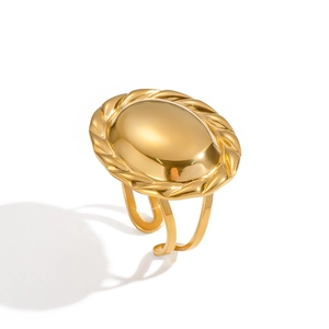 Macro detail of a vintage oval 18K gold ring with a textured braided edge on white background