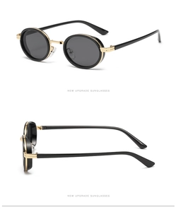 Detail view of retro oval sunglasses with black frames and golden double bridge metal accents