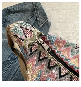 Détail macro de la fermeture éclair argentée sur un sac bandoulière tissé bohème coloré