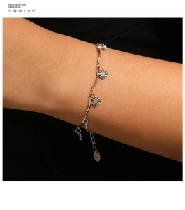 Detailed shot of silver wavy sunflower bracelet with K18 engraved tag and adjustable chain