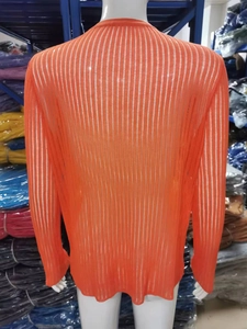 Macro view of breathable orange ribbed knit fabric texture on a long sleeve top