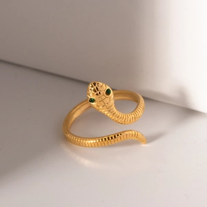 Minimalist gold snake ring with green stone eyes and adjustable curved wrap design