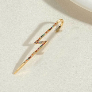Detail einer blitzförmigen Ohrmanschette in Gold mit bunten Regenbogen-Zirkonia-Steinen