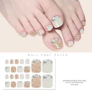 Macro detail of J23-15 toe nail stickers in light grey-green with gold glitter and rhinestones
