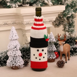 Cozy knitted snowman wine bottle cover displayed on a festive Christmas fireplace mantel