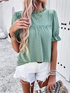 Detail of green hollow-out eyelet embroidery top with puff sleeves and ruffled neckline