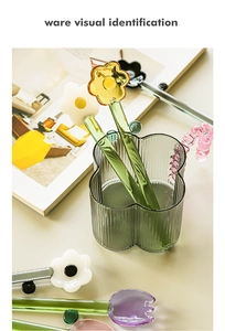 Colorful floral long handle glass spoons and heart shaped mug on a magazine background