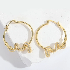 Macro shot of gold hoop earrings with twisted rope design and inlaid zircon stones