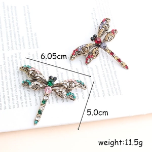 Vintage dragonfly brooch in aged gold metal with colorful rhinestones, 6.05cm wide