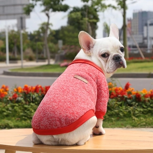 Detail view of red knitted pet sweater with ribbed cuffs and vintage classic leather patch