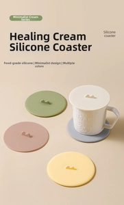 Close-up of food-grade silicone cup coasters and lids in cream colors with small handles