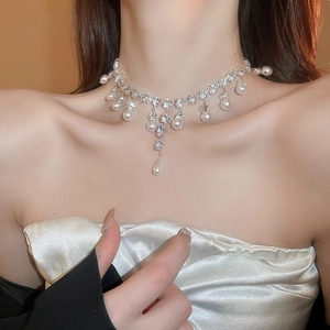 Detail of elegant silver choker necklace with round pearls and teardrop crystal pendant