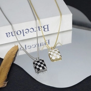 Macro detail of checkered rectangular pendants in gold and silver with elegant reflections