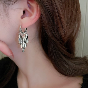 Silver leaf tassel earrings shown on model with polished metallic finish and high shine