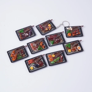 Set aus 9 Miniatur-Grill-Schlüsselanhängern mit realistischen Harz-Lebensmitteln auf Weiß
