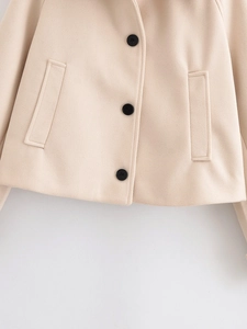 Detailed view of short wool blend jacket featuring black buttons and side pocket stitching